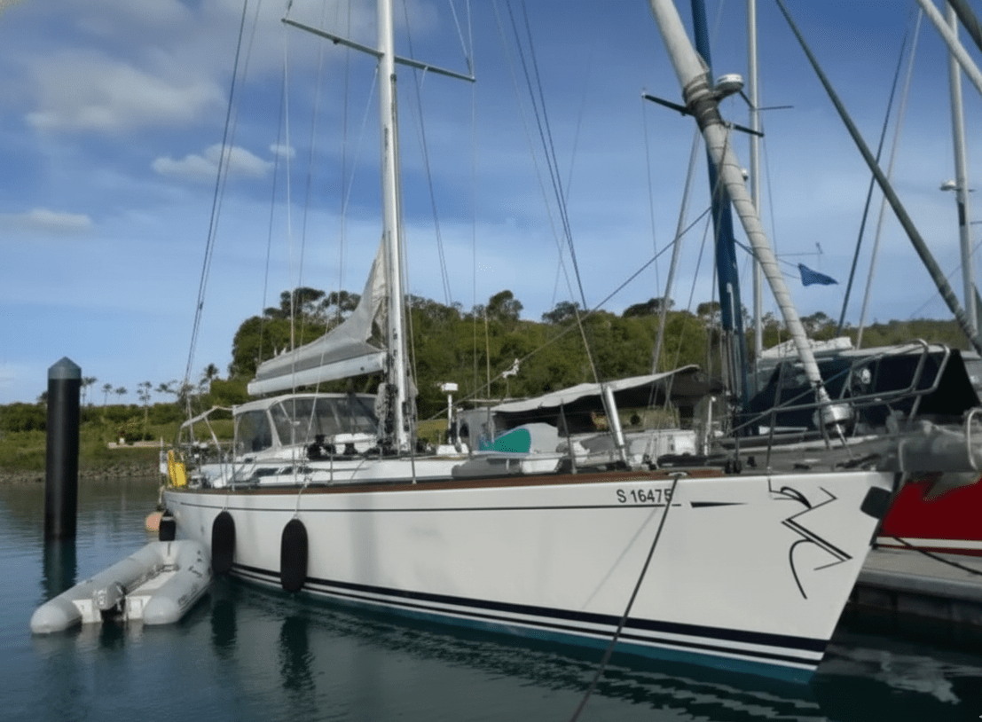 white Swan 60 on the dock with 2 dark blue fenders and a grey dinghy in the water while its being prepared for a yacht delivery in Fiji